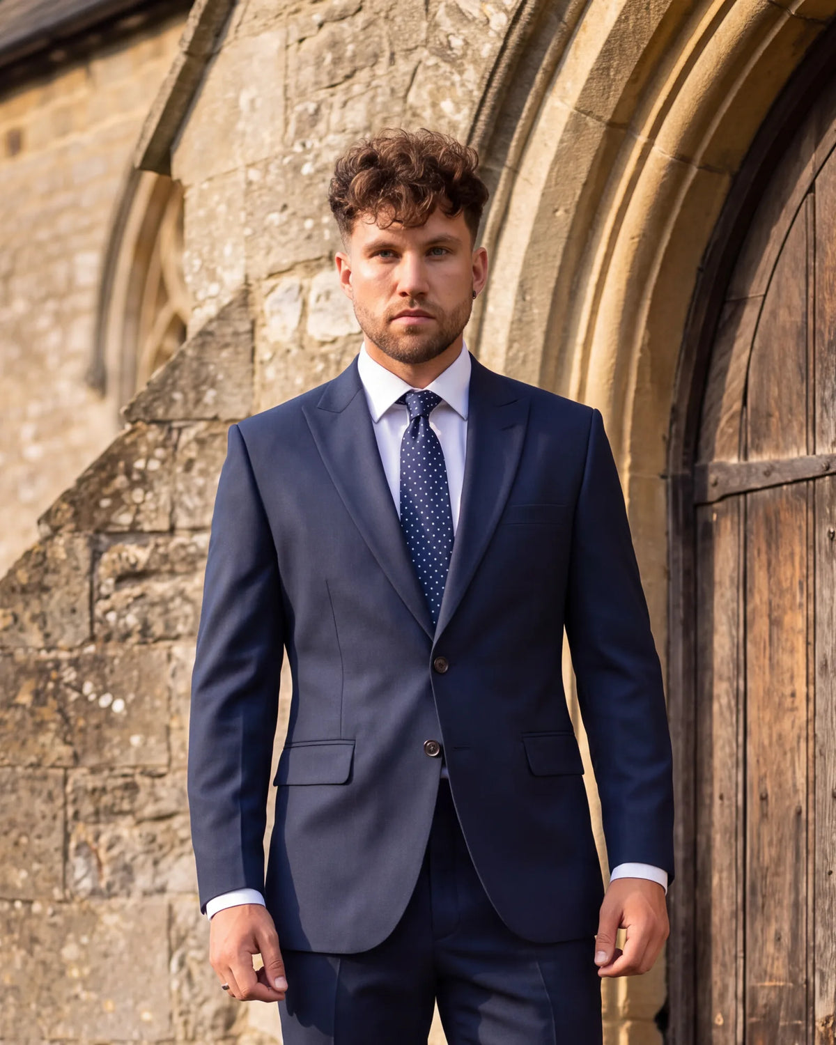 This navy suit and dark tie are right for a church wedding. If you are unsure about a ceremony, ask the couple first.