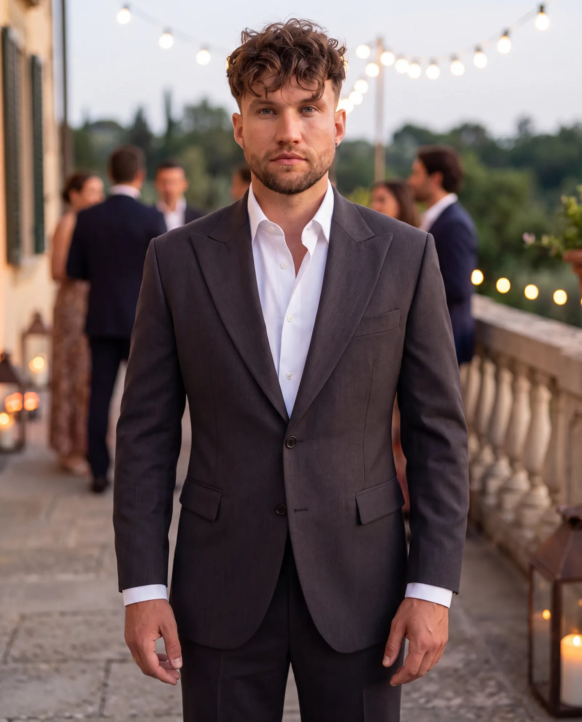 This charcoal suit with an open collar fits a welcome party, usually one step less formal than the wedding.