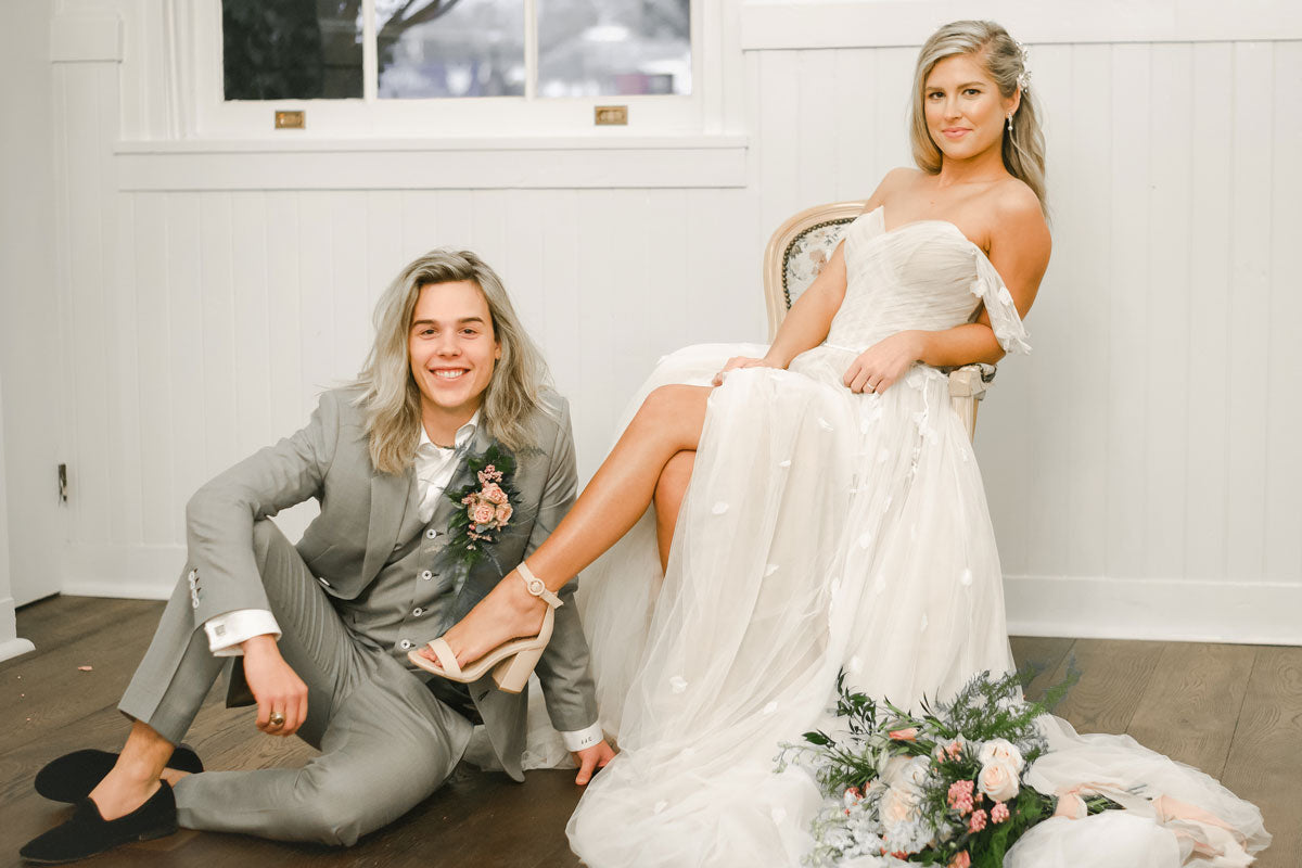 wedding couple with groom sitting on the ground and bride in a chair