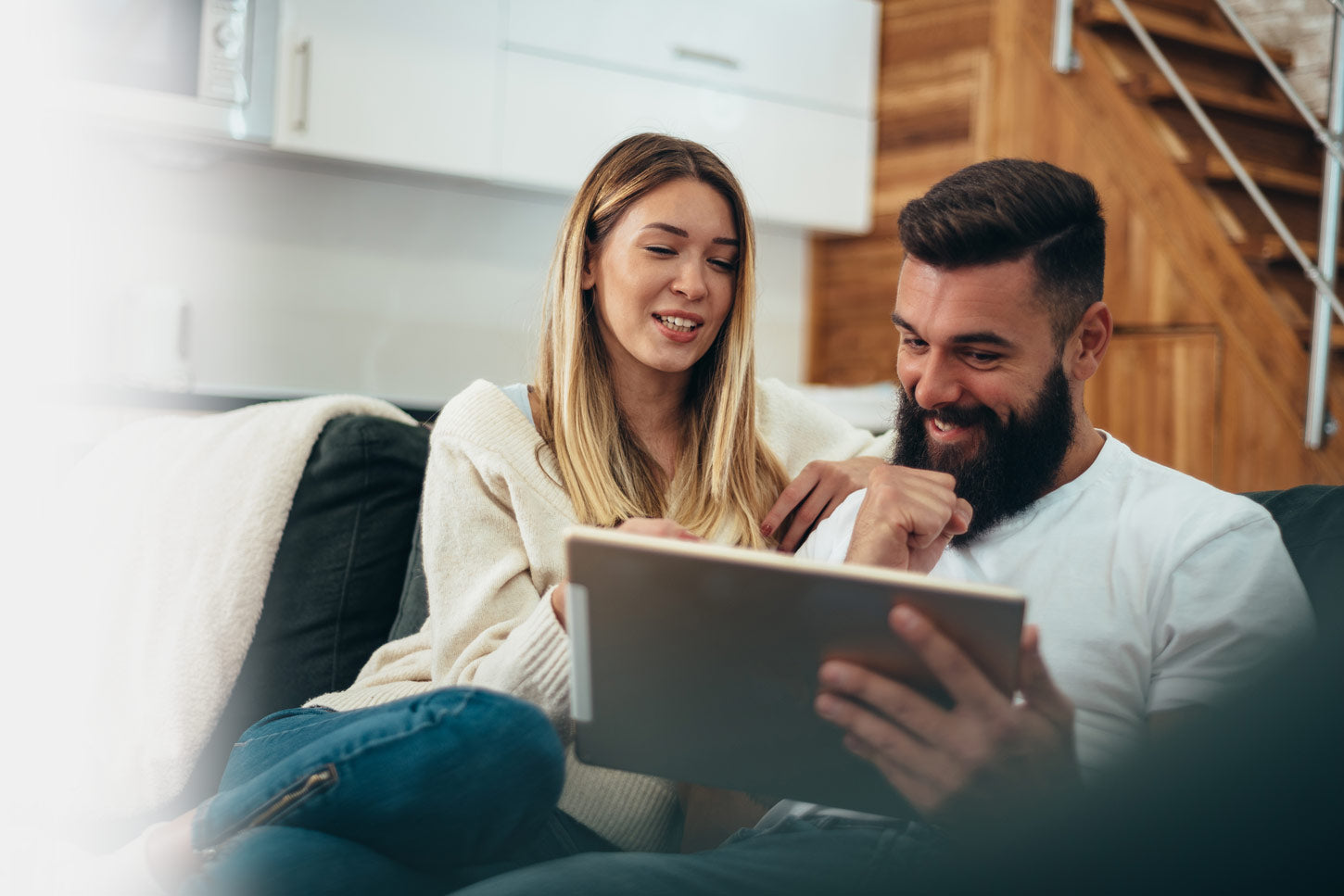 couple on couch looking at tablet