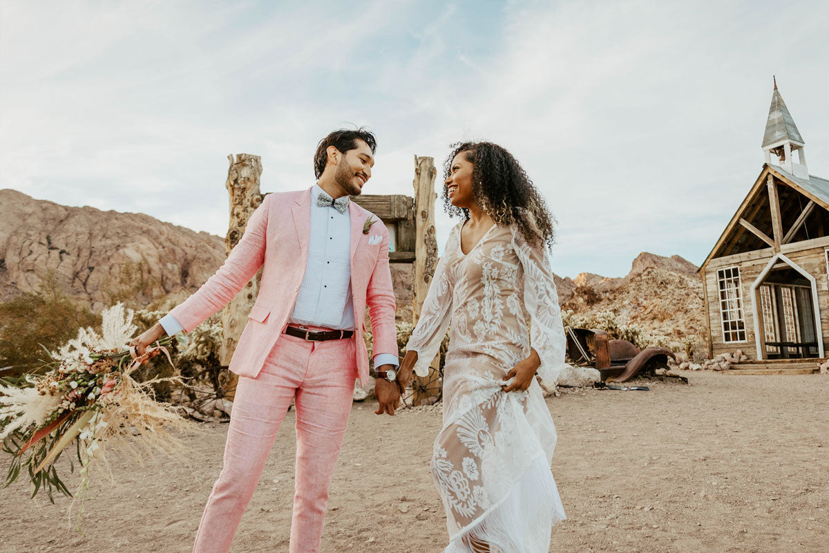 wedding couple in ghost town. groom in pink suit.