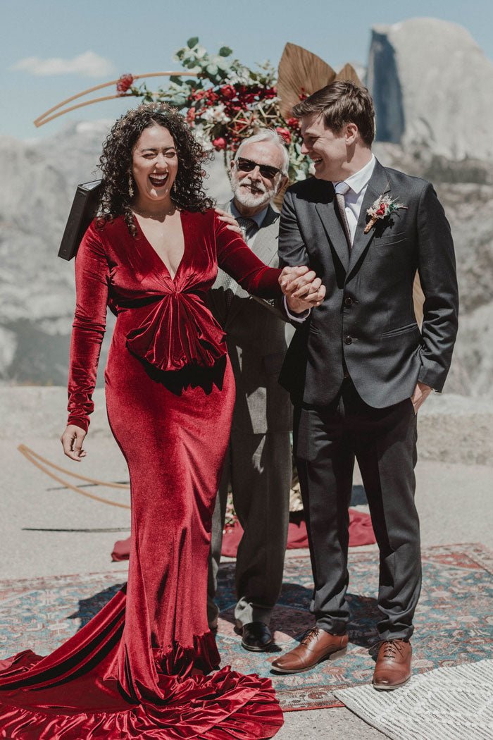 bride in red dress and groom in dark grey suit