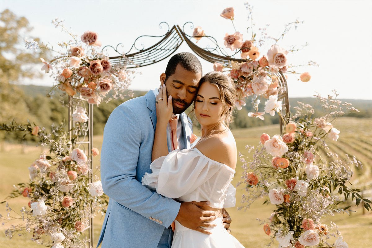 wedding couple embracing at the alter overlooking a vineyard