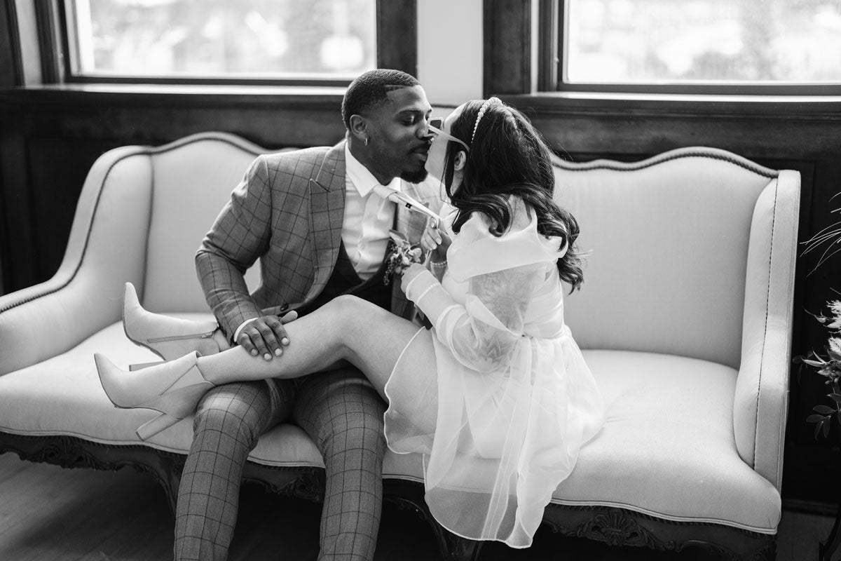bride and groom sitting on sofa embracing