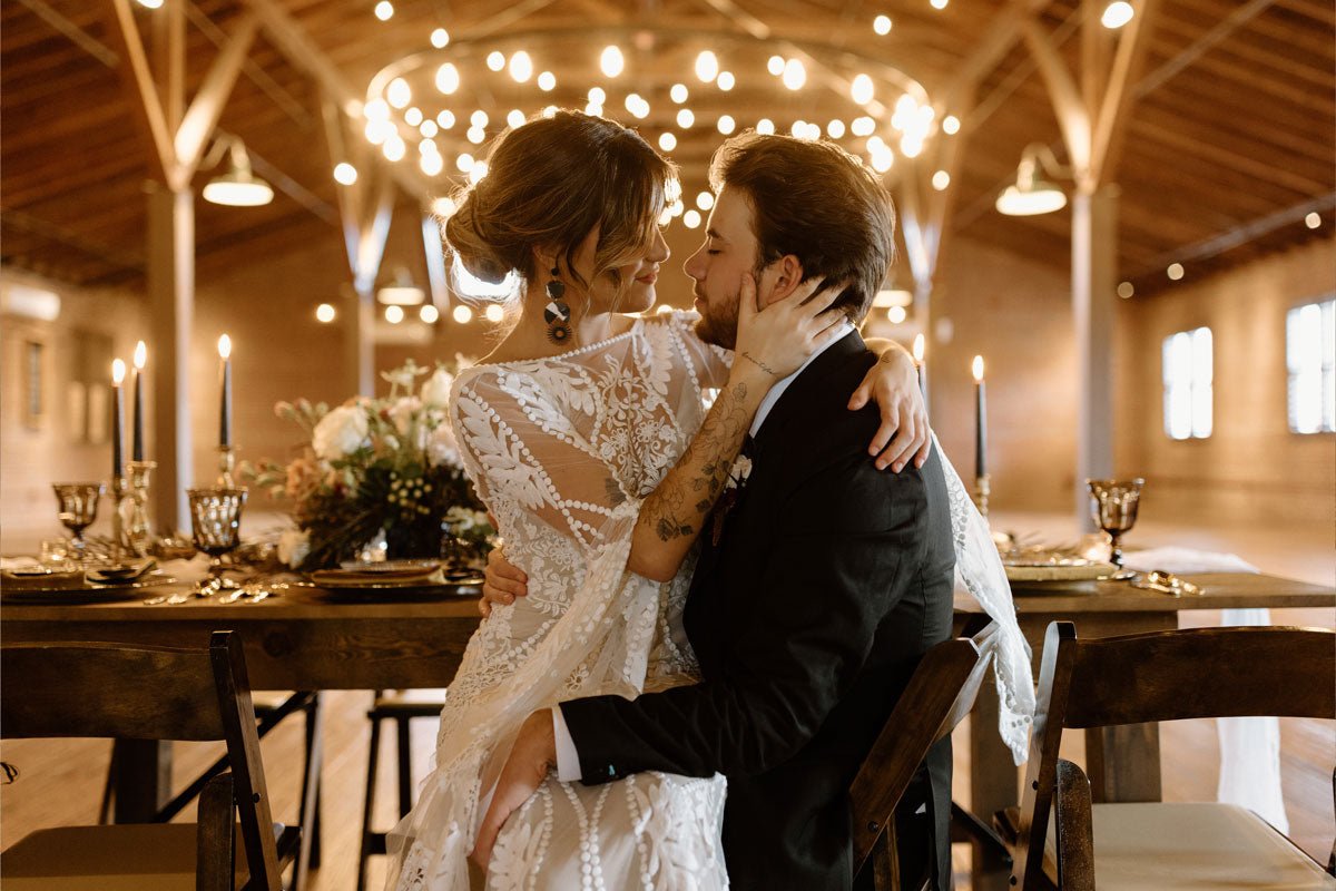 bride and groom embracing at the wedding dinner table