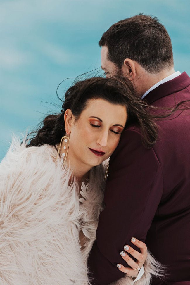 close up of bride and groom embracing on glacier