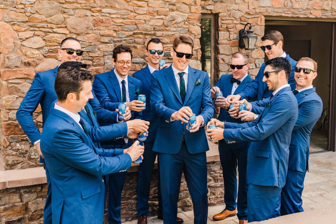 wedding party cracking open beers while getting ready for the wedding