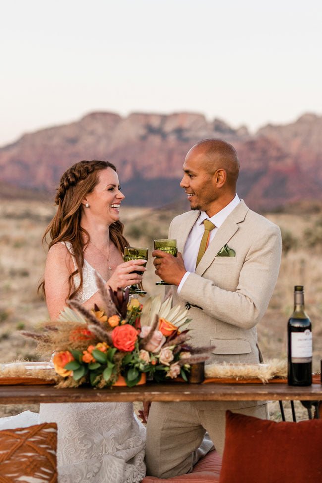 groom smiling in three piece grey suit with groomsmen behind him