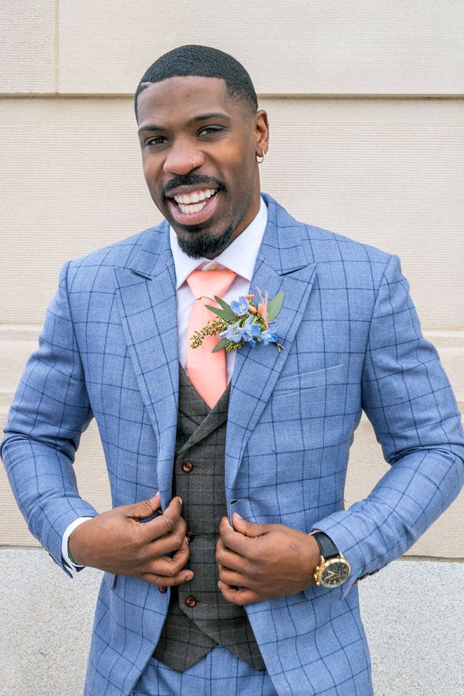 groom in blue windowpane suit smiling