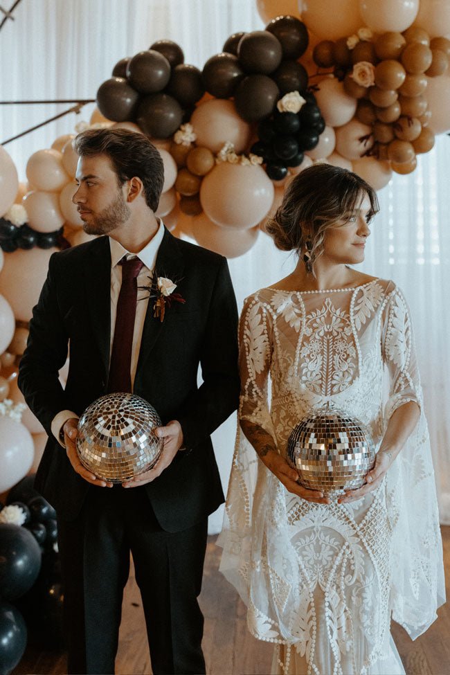 bride and groom holding disco balls