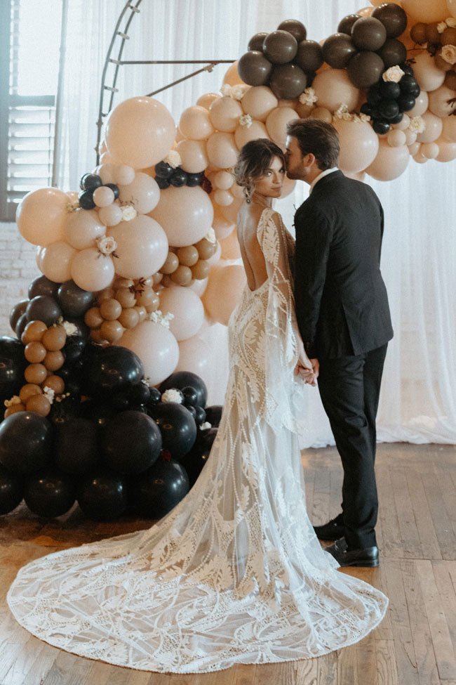 bride and groom posing in front of balloons