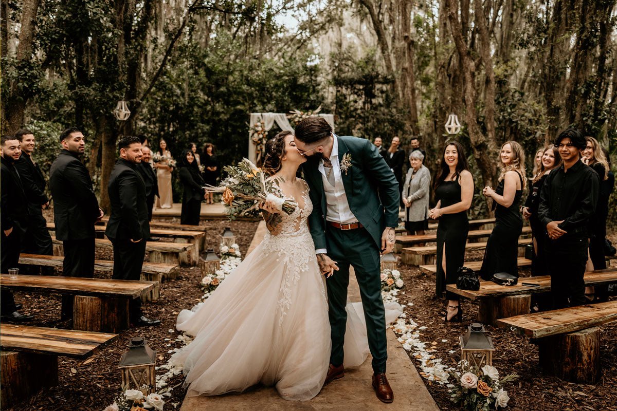 taupe linen suit on a groom with bride eating wedding cake in the savannah