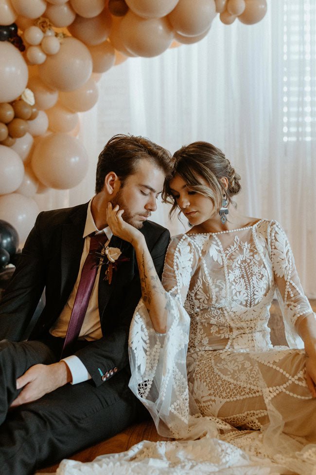 bride and groom sitting in front of balloons