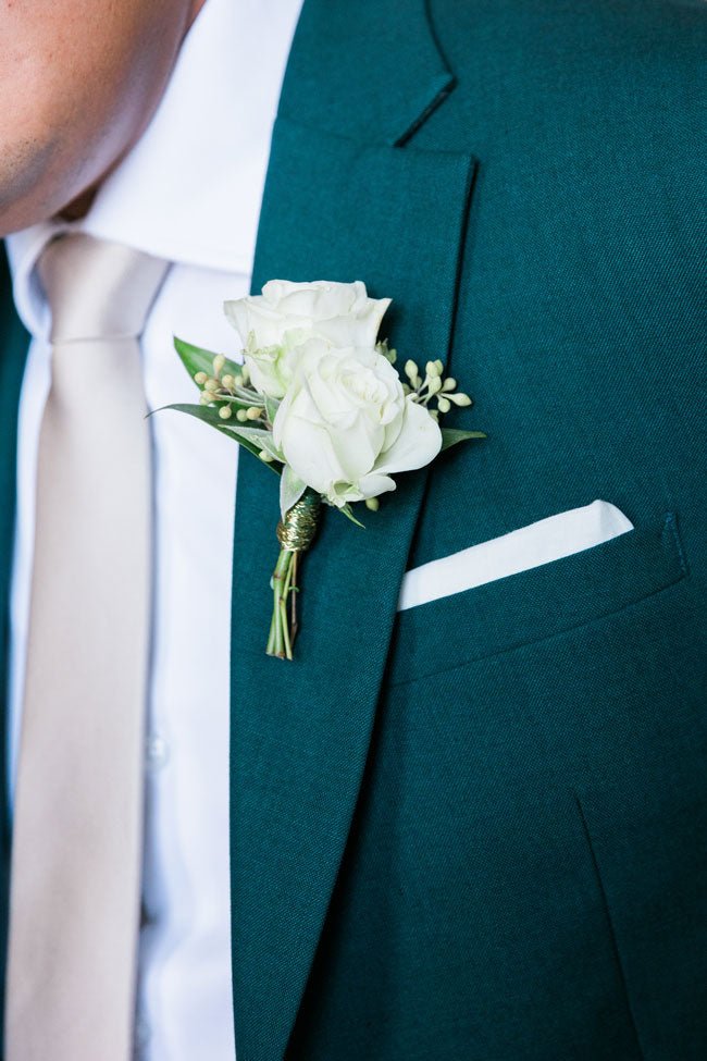 close up shot of a flower on a green suit