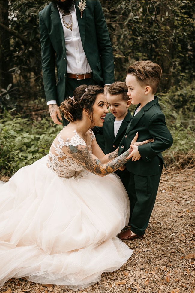 bride crotching down to smile at her two kids