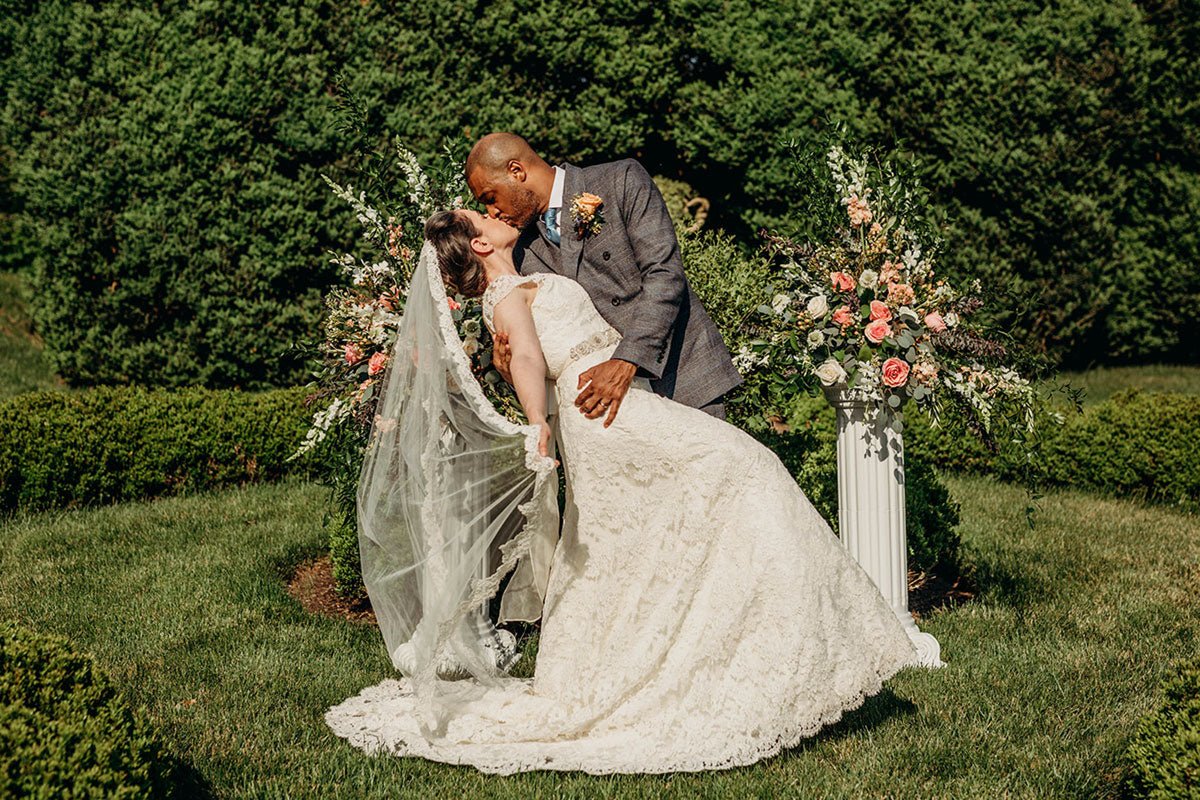 bride and groom being cheered on by the wedding party while they walk through the lawn
