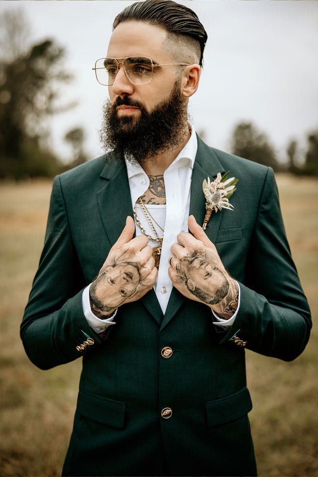 groom in green suit with hand tattoos of his kids