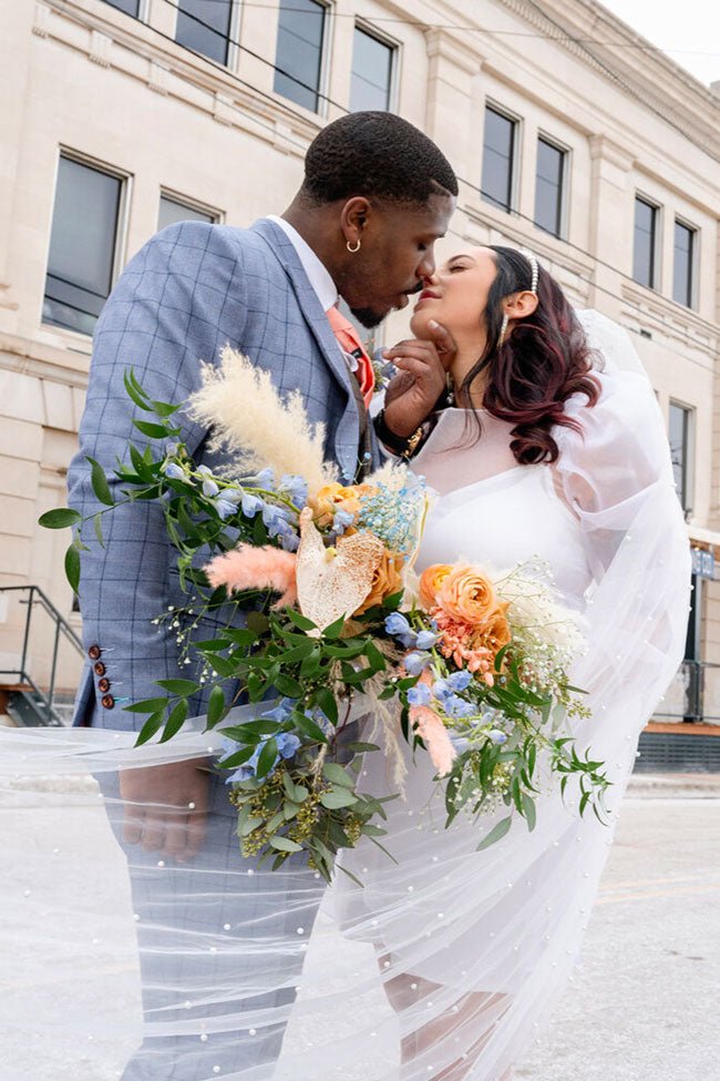 wedding couple embracing with flowers