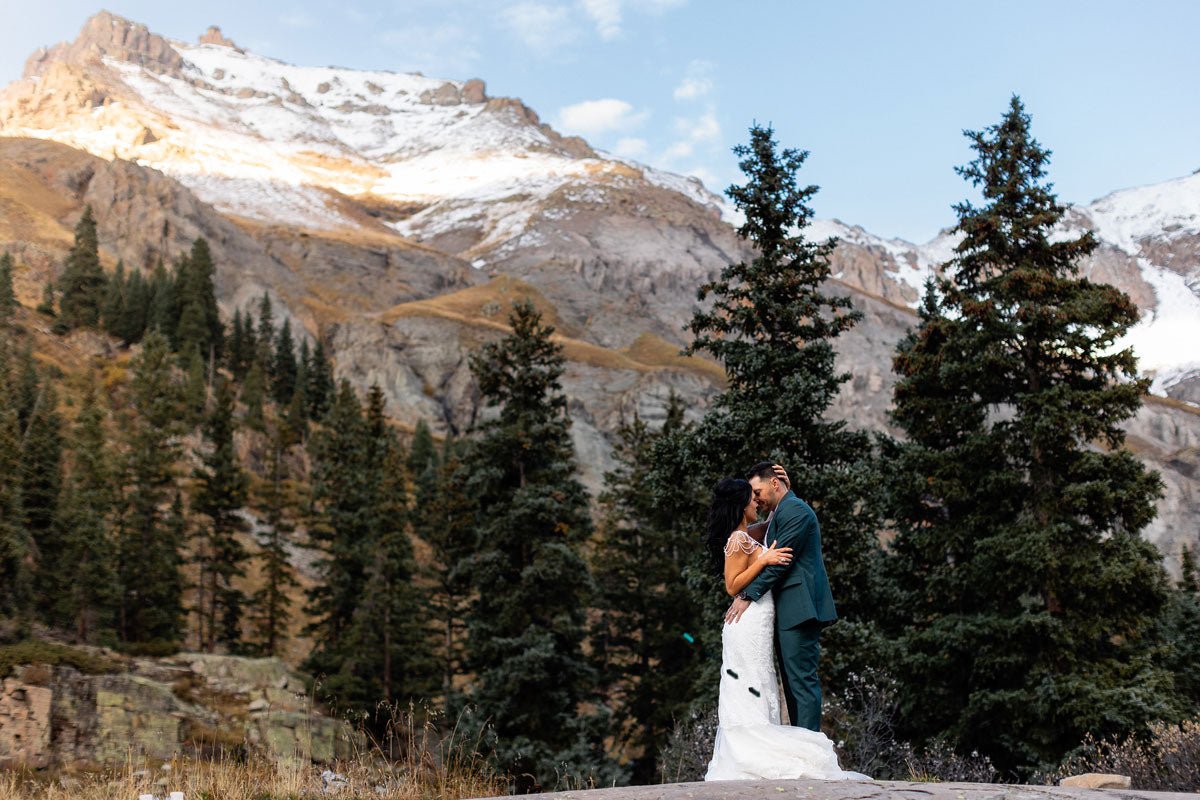 bride and groom kissing in a mountain valley