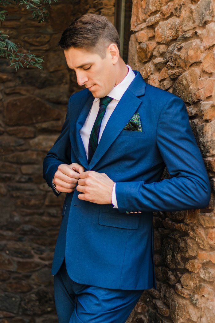 groom adjusting his blue suit