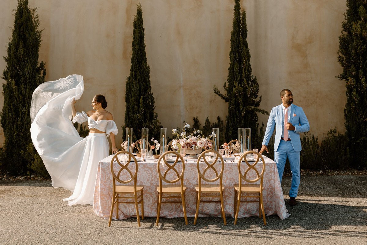 bride and groom standing on opposite sides of their outdoor wedding dinner table